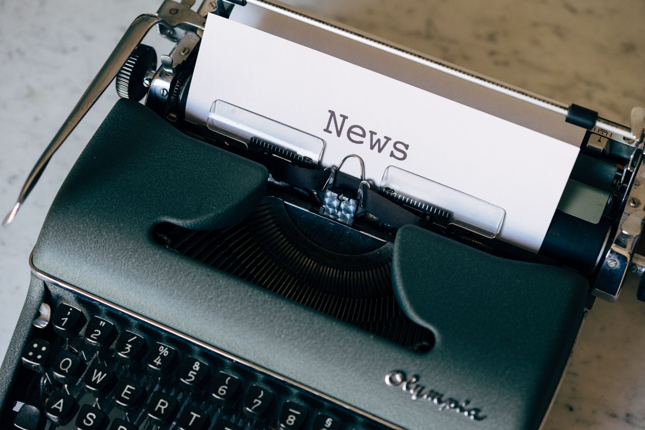 our-journey-02 A vintage typewriter with a paper titled 'News', symbolizing journalism and communication.