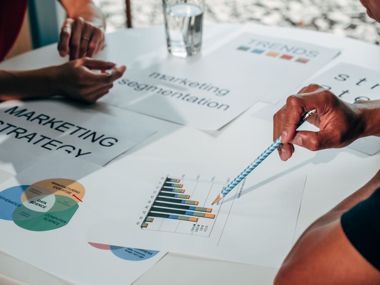 experience-img Team working on marketing strategy using data charts and papers in an office meeting.